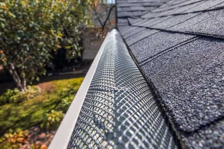 A contractor demonstrating the effectiveness of a gutter guard to a potential client in Roanoke